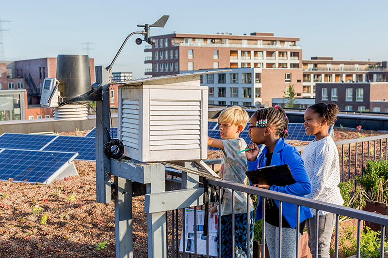 Leerlingen doen onderzoek naar weer en klimaat met behulp van een weerstation op het groene dak van het schoolgebouw. Foto: Timon Jacob